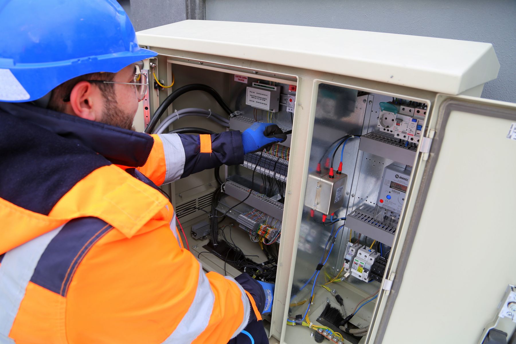 Illustrative stock photo of an electrician working at an electrical cabinet